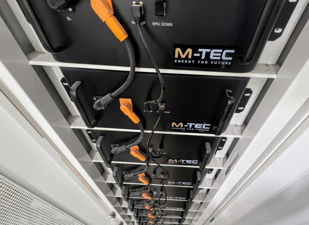 Pequeños bloques negros con cables unidos y colocados unos encima de otros. Cada bloque tiene el logotipo de M-TEC