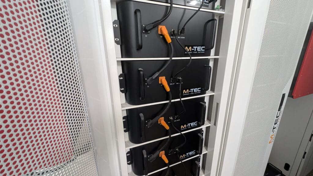 Pequeños bloques negros con cables unidos y colocados unos encima de otros. Cada bloque tiene el logotipo de M-TEC
